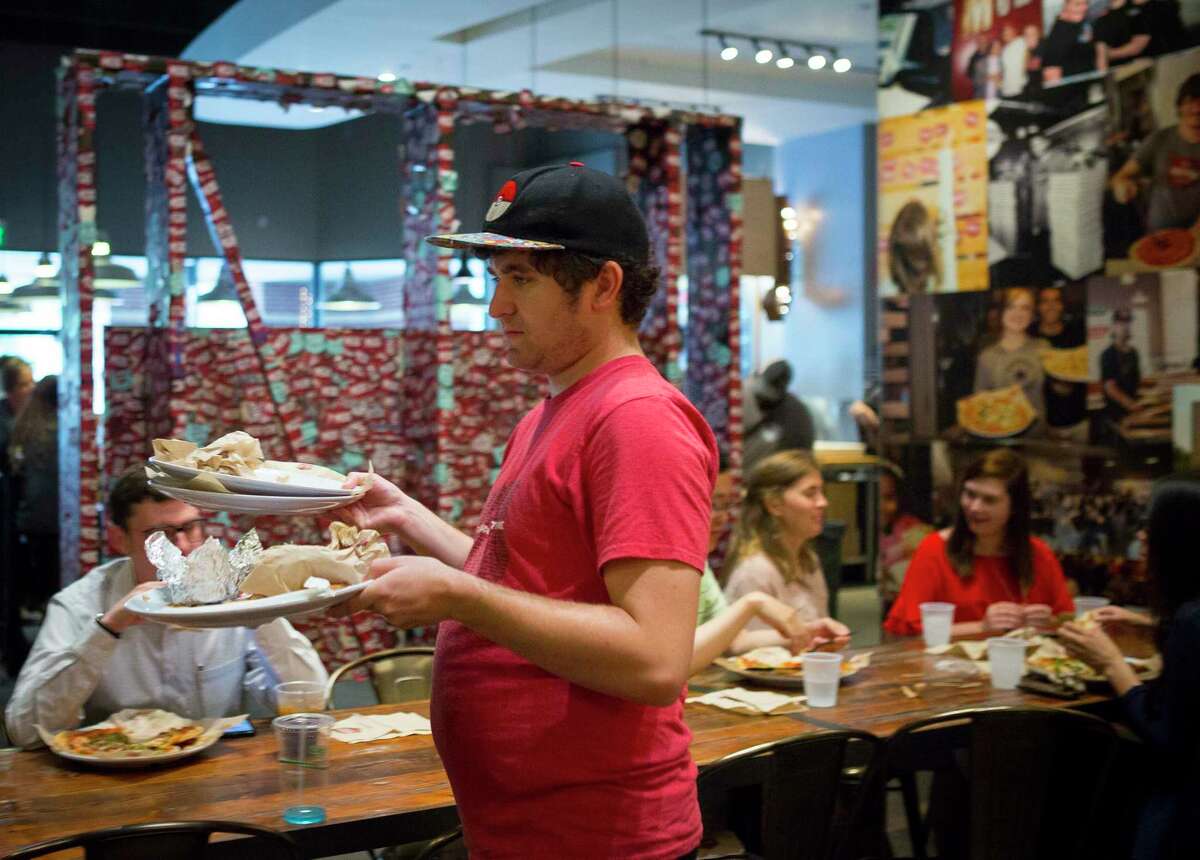 Jordan Caldwell buses tables at the MOD Pizza West Galleria location. Caldwell, who has autism, has been working at MOD Pizza since 2017. ( Mark Mulligan / Houston Chronicle )