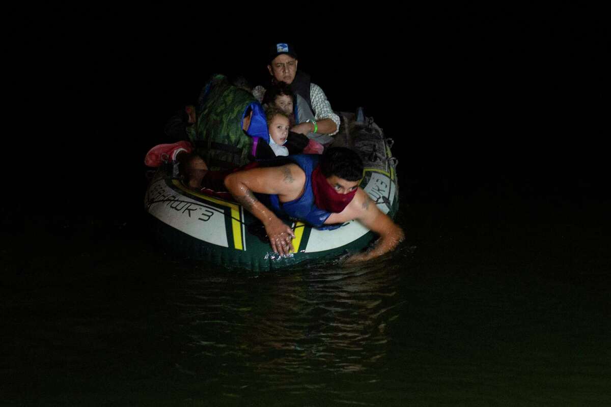 A smuggler takes migrants, mostly from Central American countries, on a small inflatable raft towards U.S. soil in Roma, Texas Tuesday, March 30, 2021. Roma, a town of 10,000 people with historic buildings and boarded-up storefronts in Texas' Rio Grande Valley, is the latest epicenter of illegal crossings, where growing numbers of families and children are entering the United States to seek asylum. (AP Photo/Dario Lopez-Mills)