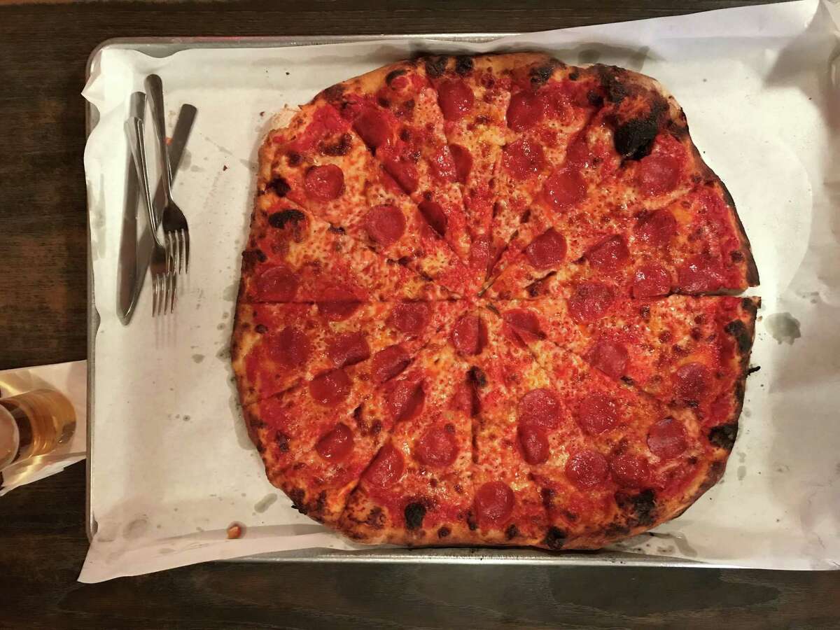 A tomato, mozzarella, and pepperoni pizza from Sally's Apizza on New Haven’s Wooster Street