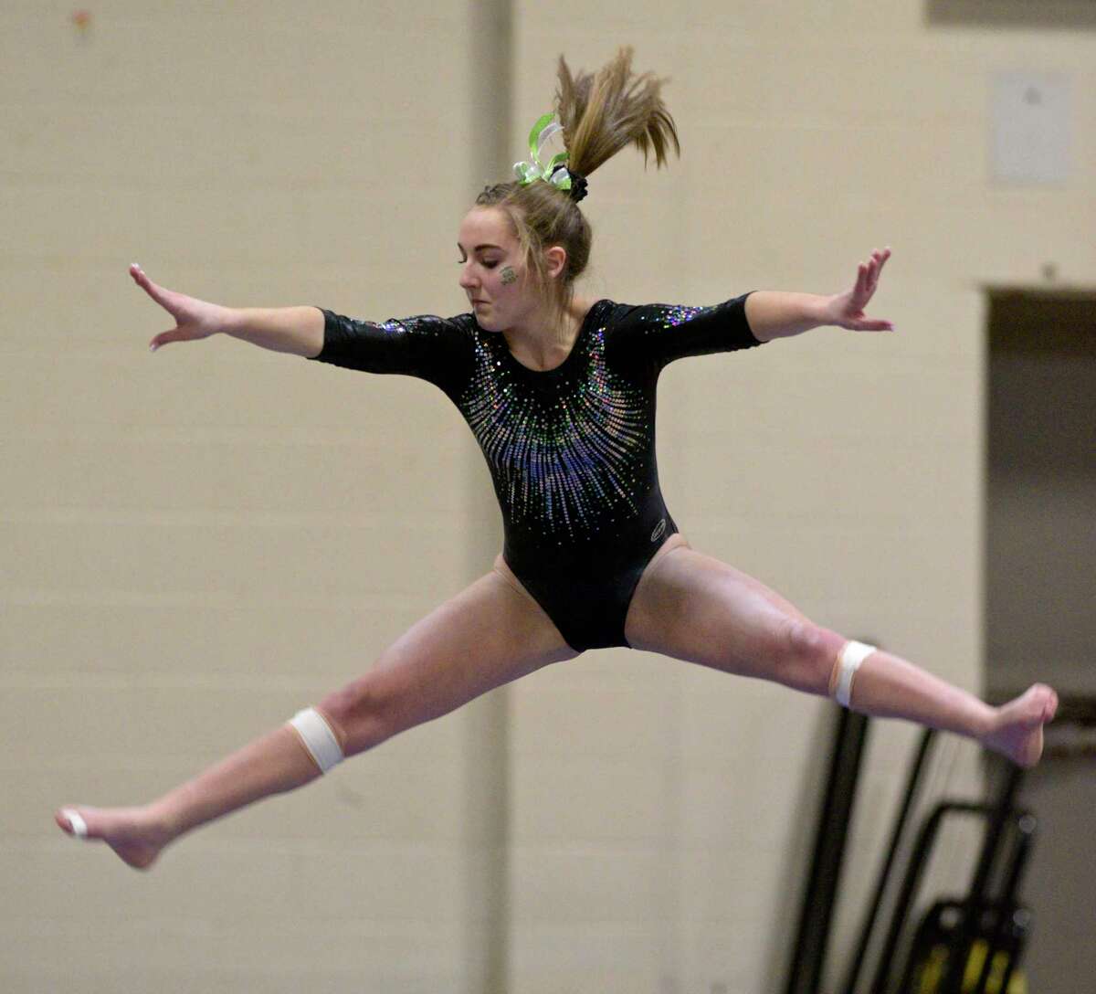 New Milford High School's Hailey Best competes on the beam during the SWC gymnastics championships, Thursday night, February 13, 202, at New Milford High School, New Milford, Conn.