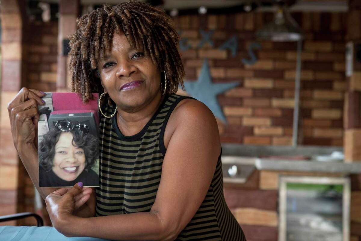 Janice Carter poses for a portrait holding a photo of her late sister, Deborah Kiel, on her back porch Wednesday, March 31, 2021 in Houston. Kiel died after losing power during the February winter storm.