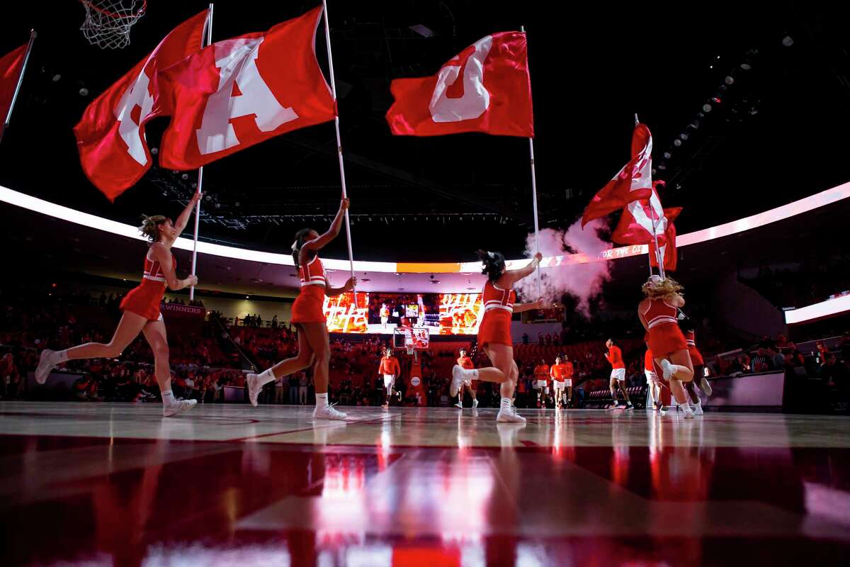 Cheerleaders at the University of Houston run with banners during the introductions for the Cougars' mens basketball game against the Southern Methodist University Mustangs at the Fertitta Center in Houston, Wednesday, Jan. 15, 2020.