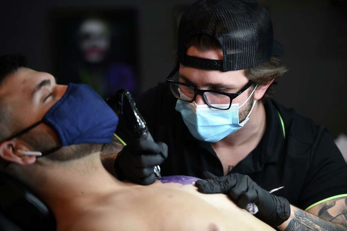 Jonathan Gioia, owner of Empire Tattoo in Orange, works on the outline of a tattoo on the chest of Yakup Kir of East Haven on March 30, 2021.