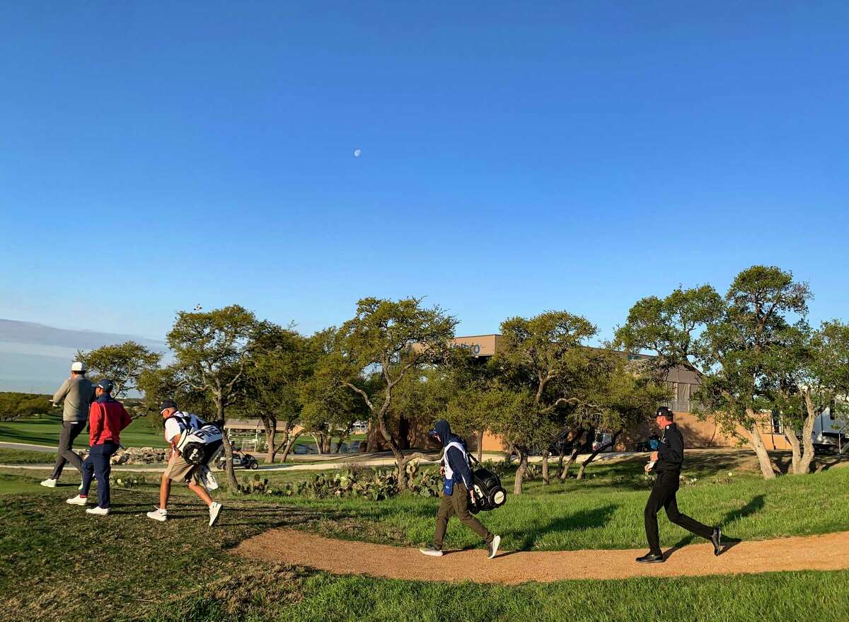 Jimmy Walker, right, joins other golfers and caddies as they walk on the 10th during the morning of the opening round of the Valero Texas Open at the TPC San Antonio - AT&T Oaks Course on Thursday, April 1, 2021.