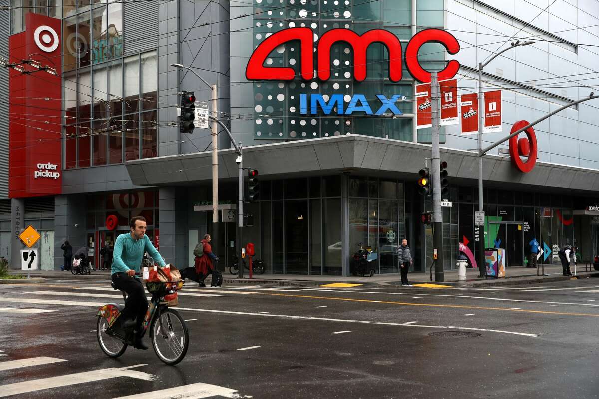 A cyclist rides his bike by an AMC theatre on April 6, 2020, in San Francisco.