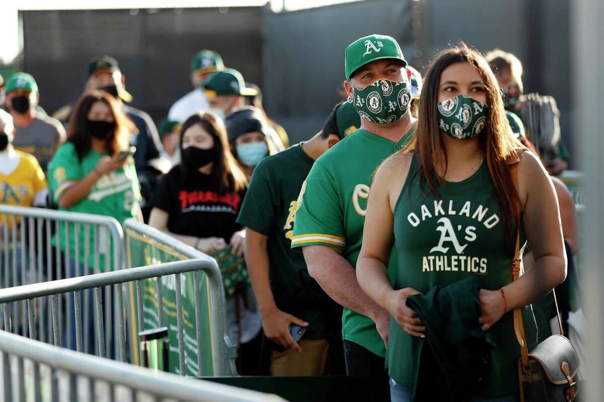 Angela and Nick Tostado of Martinez wait to enter before Oakland Athletics play Houston Astros in season opener at Oakland Coliseum in Oakland, Calif., on Thursday, April 1, 2021.