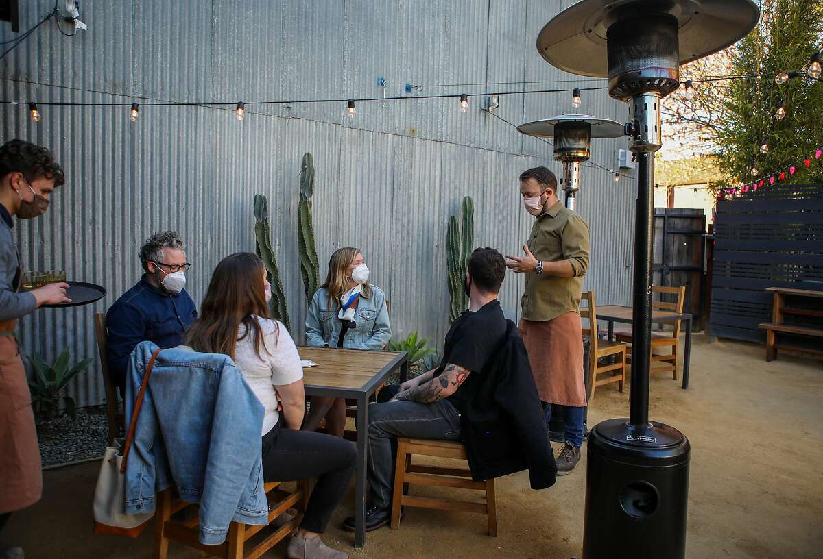 Sam Benson (left) serves water as co-partner Tanner Walle greets guests March 12 at Valley Bar & Bottle, a new wine shop, bar and restaurant in Sonoma.