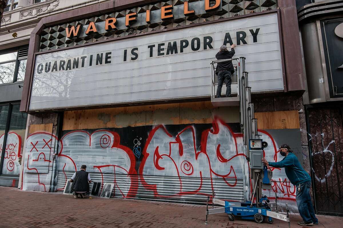 Tom Hazlett, Matt Albrecht and Christian Lewis change the marquee at the Warfield Theatre in January.