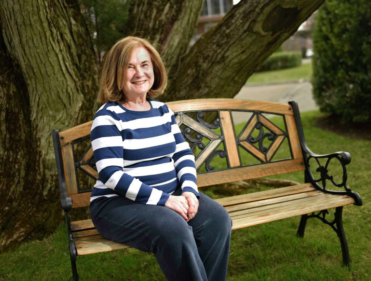 Judy Bring, 77, poses outside her home in Greenwich, Conn. Thursday, April 1, 2021. Bring has been very cautious about COVID from the start and has only seen her grandchildren and children in Boston once in the last year.
