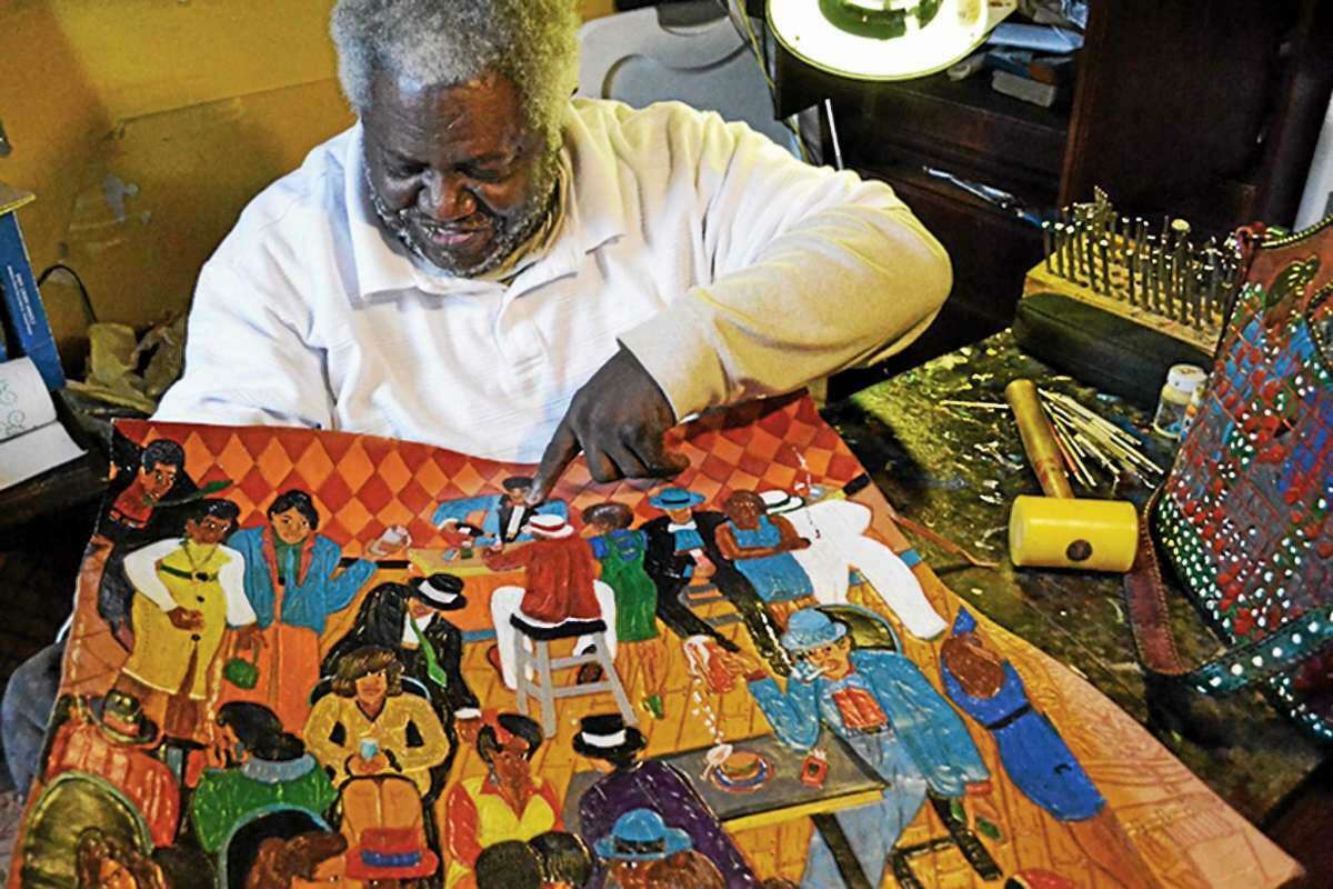 Nationally recognized, Georgia-born artist Winfred Rembert, who has lived much of his life in the Newhallville section of New Haven, posing with his work in leather, 