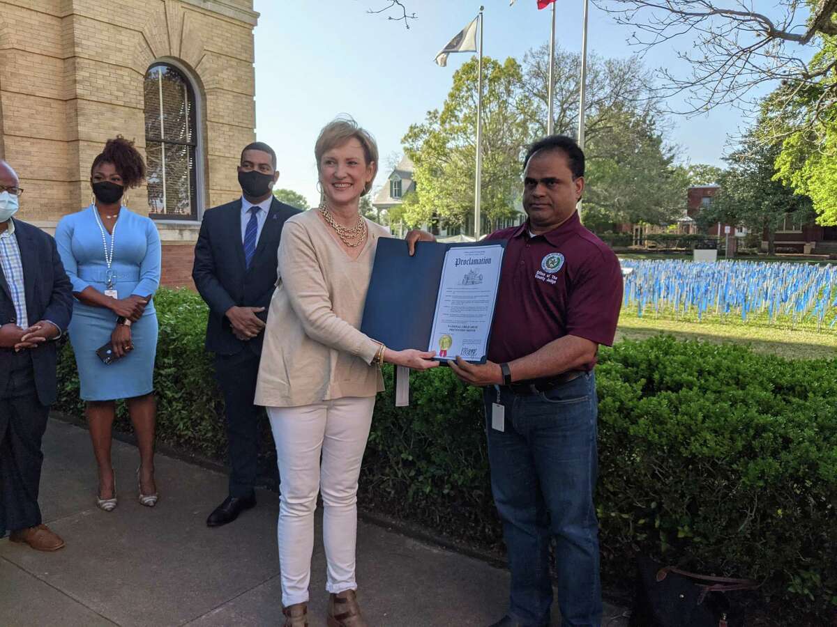 Fort Bend County Judge KP George presents a proclamation to Kelly Metzenthin, president of the Exchange Club of Fort Bend, recognizing the club's efforts in combatting child abuse.