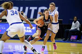 Connecticut guard Nika Muhl (10) drives to the basket against Creighton guard Carly Bachelor (22) during an NCAA college basketball game Thursday, Feb. 25, 2021, in Omaha, Neb. (AP Photo/John Peterson)