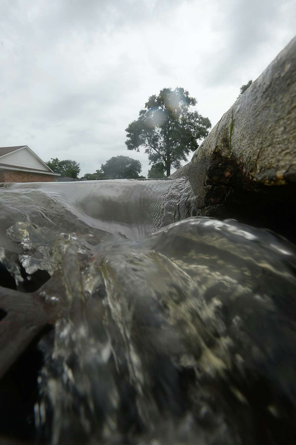 Water pours into a storm drain on 31st Street in Nederland as spotty bursts of rain move through the area Saturday, briefly accumulating on streets near Nederland Avenue, which is prone to flooding in heavy rainfalls. Heavier rains and wind from the outer bands of Hurricane Harvey, which was downgraded to a tropical storm, are expected to impact the Southeast Texas region within the coming days, increasing the risk for severe flooding. Photo taken Saturday, August 26, 2017 Kim Brent/The Enterprise
