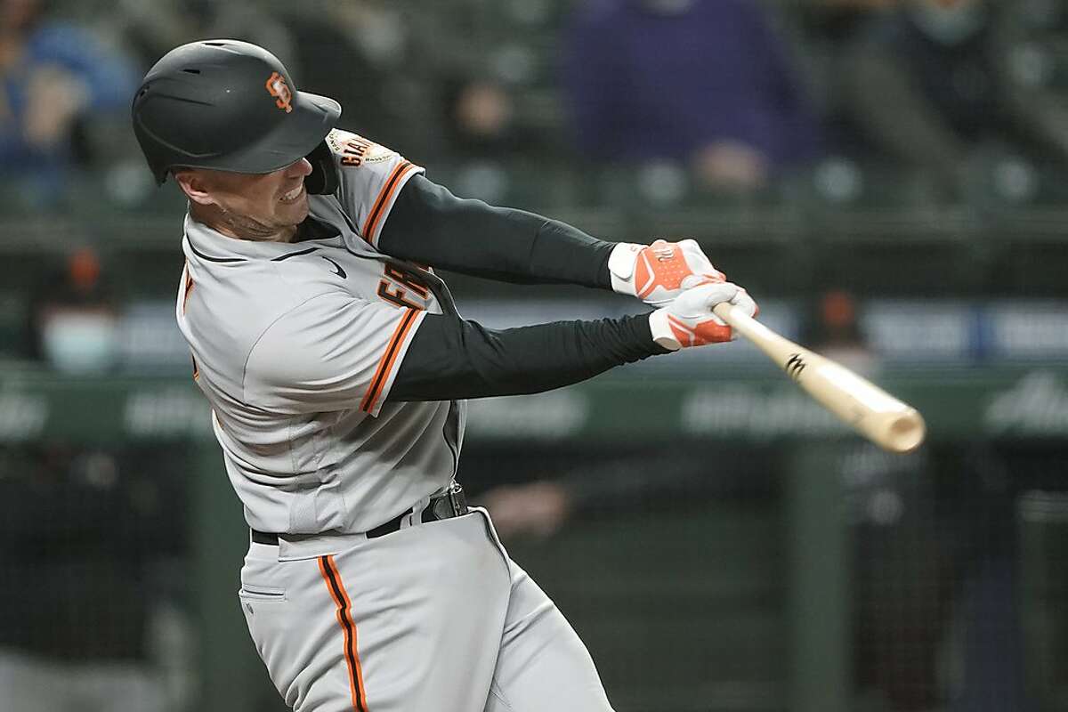 San Francisco Giants' Buster Posey hits a solo home run during the third inning of a baseball game against the Seattle Mariners, Friday, April 2, 2021, in Seattle. (AP Photo/Ted S. Warren)