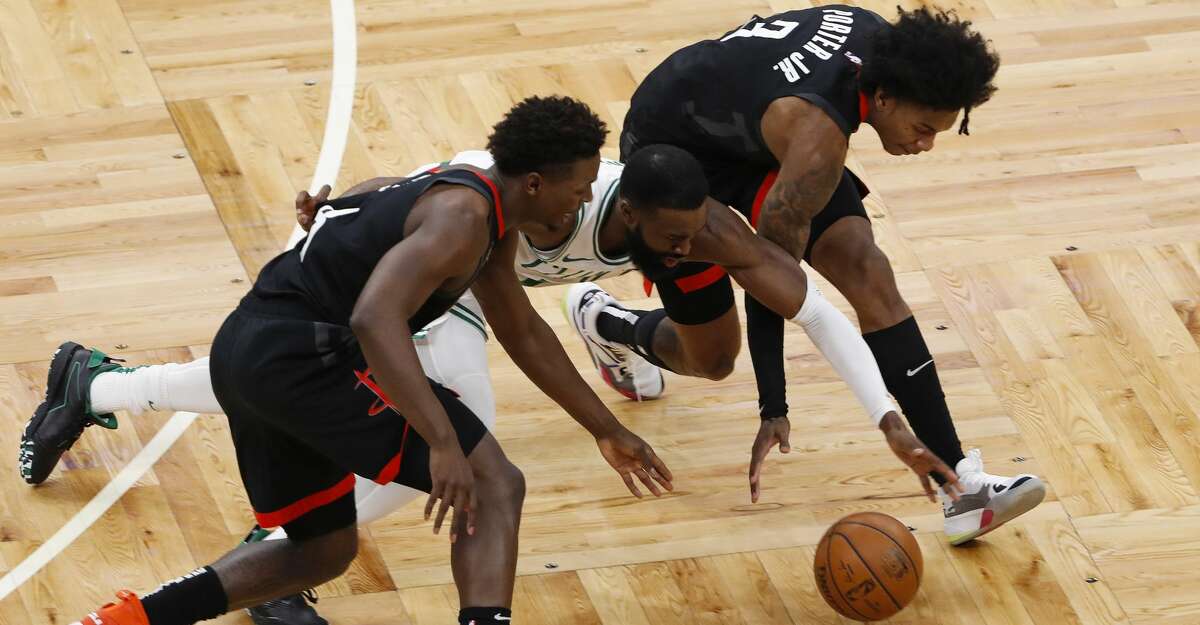Boston Celtics' Jaylen Brown reaches for a loose ball between Houston Rockets' Kevin Porter Jr., right, and Jae'Sean Tate during the second quarter of an NBA basketball game Friday, April 2, 2021, in Boston. (AP Photo/Winslow Townson)