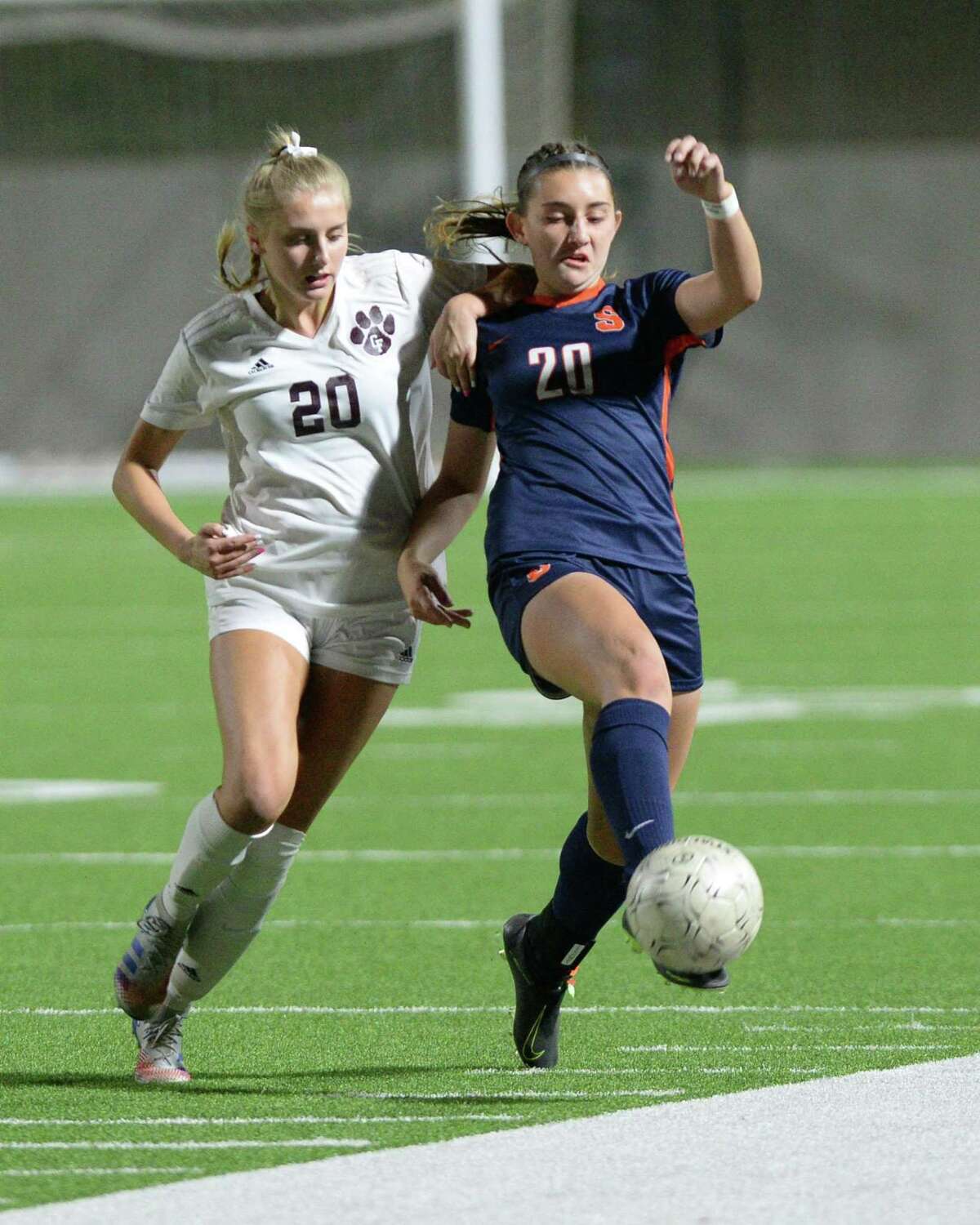 Katie Lennon (20) of Seven Lakes traps a ball as Ava Drouin (20) of Cy-Fair challenges during the second half of a 6A-III regional quarterfinal soccer match between the Seven Lakes Spartans and the Cy-Fair Bobcats on Friday, April 2, 2021 at Rhodes Stadium, Katy, TX.