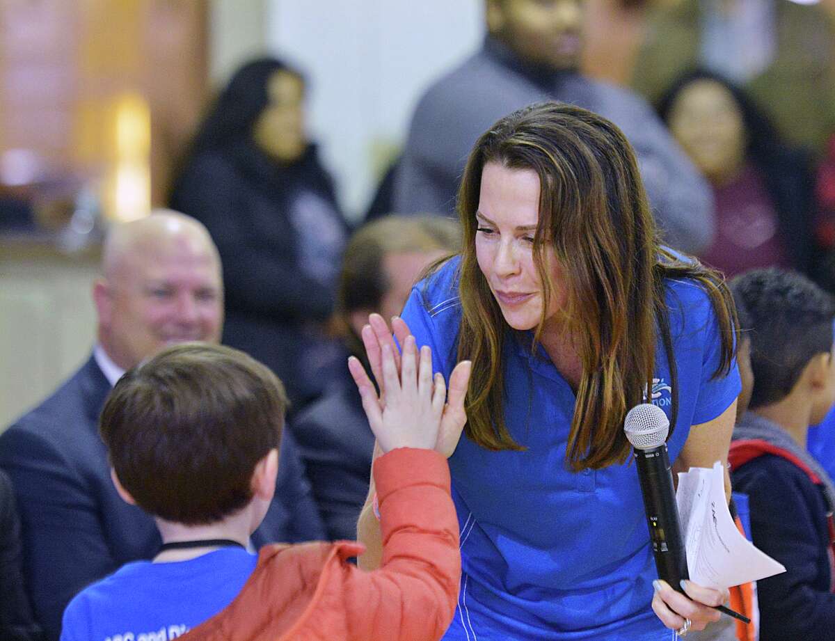Karen Cohn, right, high-fives a camper who was given a water-safety medal during the closing ceremony for the ZAC Camp at the Boys & Girls Club of Greenwich, Conn., Thursday, April 12, 2018. The camp, a water safety and pool safety program for kids, was founded by Karen Cohn and her husband Brian Cohn of Greenwich who lost their son Zachary Cohn in a 2007 pool accident.