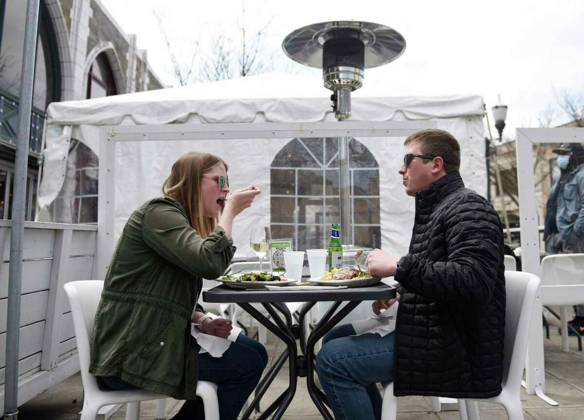 Stamford's Emily Levasseur and Craig Saphire enjoy a meal outside as part of the StrEATeries outdoor dining initiative in Stamford, Conn. Sunday, April 4, 2021. Stamford Downtown and the City of Stamford partnered to bring back the initiative that started last year in response to the ongoing coronavirus pandemic. StrEATeries adds more than 1,000 outdoor dining seats to accomodate visitors to downtown Stamford for dining and shopping.