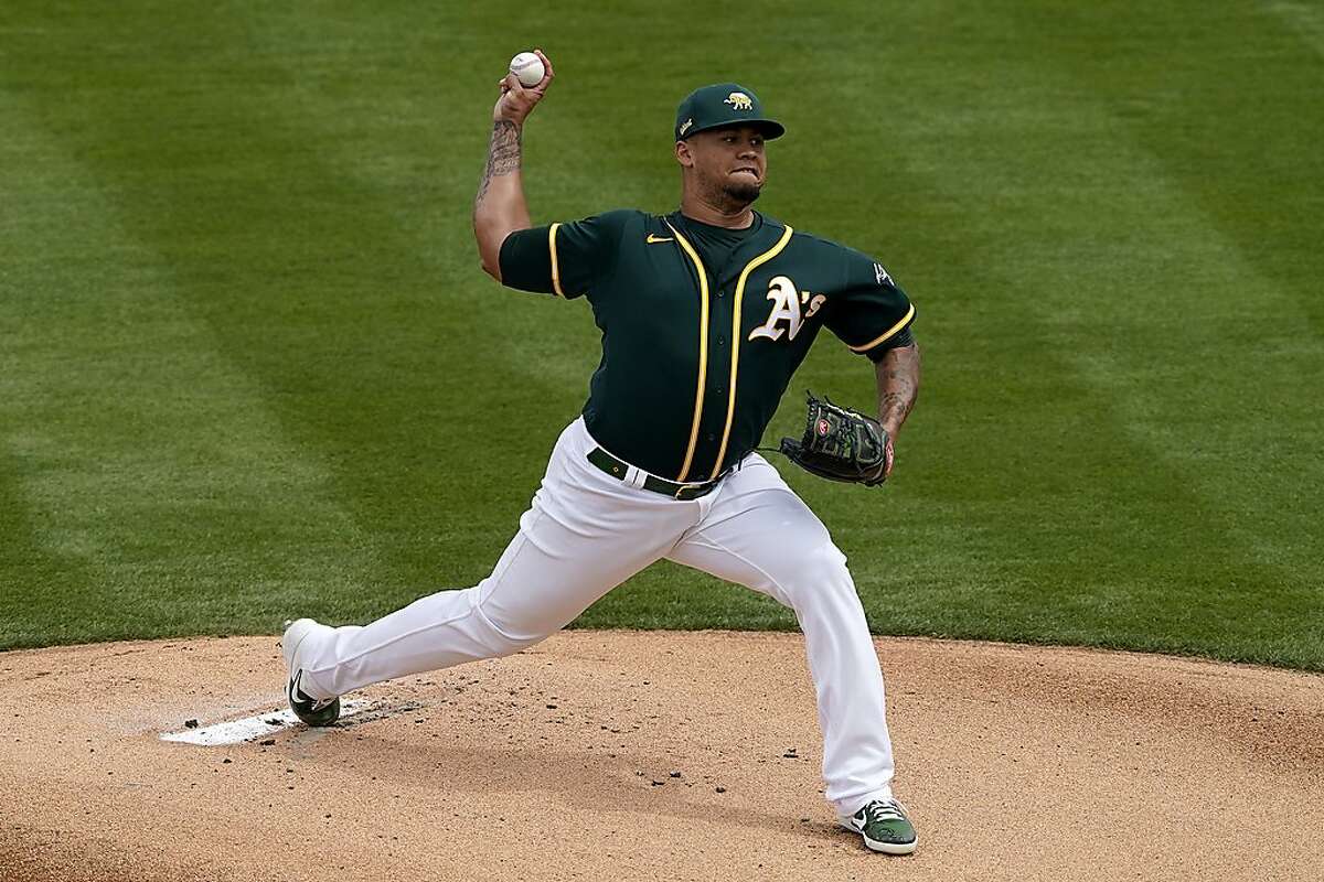 Oakland Athletics starting pitcher Frankie Montas throws agaisnt the Seattle Mariners during the first inning of a spring training baseball game, Thursday, March 25, 2021, in Mesa, Ariz. (AP Photo/Matt York)