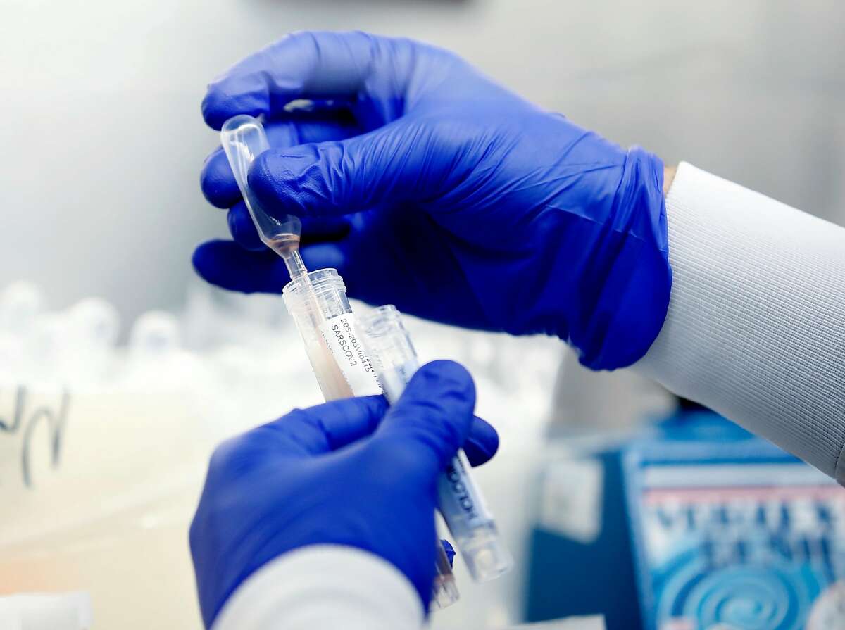 A lab assistant pools samples into a testing tube to be processed at Stanford Clinical Virology Lab in Palo Alto. 