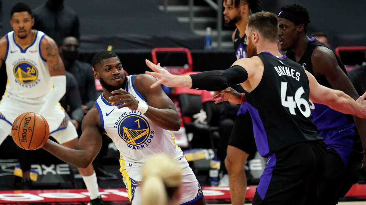 Golden State Warriors forward Eric Paschall (7) passes the ball in front of Toronto Raptors center Aron Baynes (46) during the first half of an NBA basketball game Friday, April 2, 2021, in Tampa, Fla. (AP Photo/Chris O'Meara)