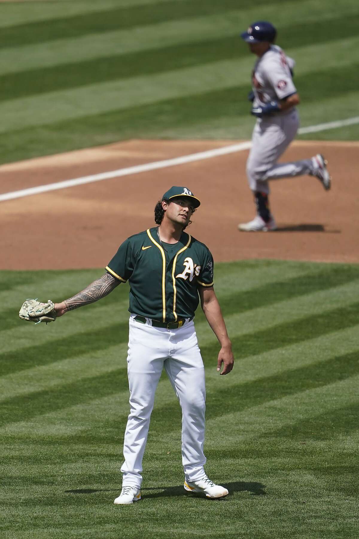 Houston Astros' Jason Castro, top, rounds the bases after hitting a two-run home run off Oakland Athletics pitcher Sean Manaea, bottom, during the second inning of a baseball game in Oakland, Calif., Sunday, April 4, 2021.