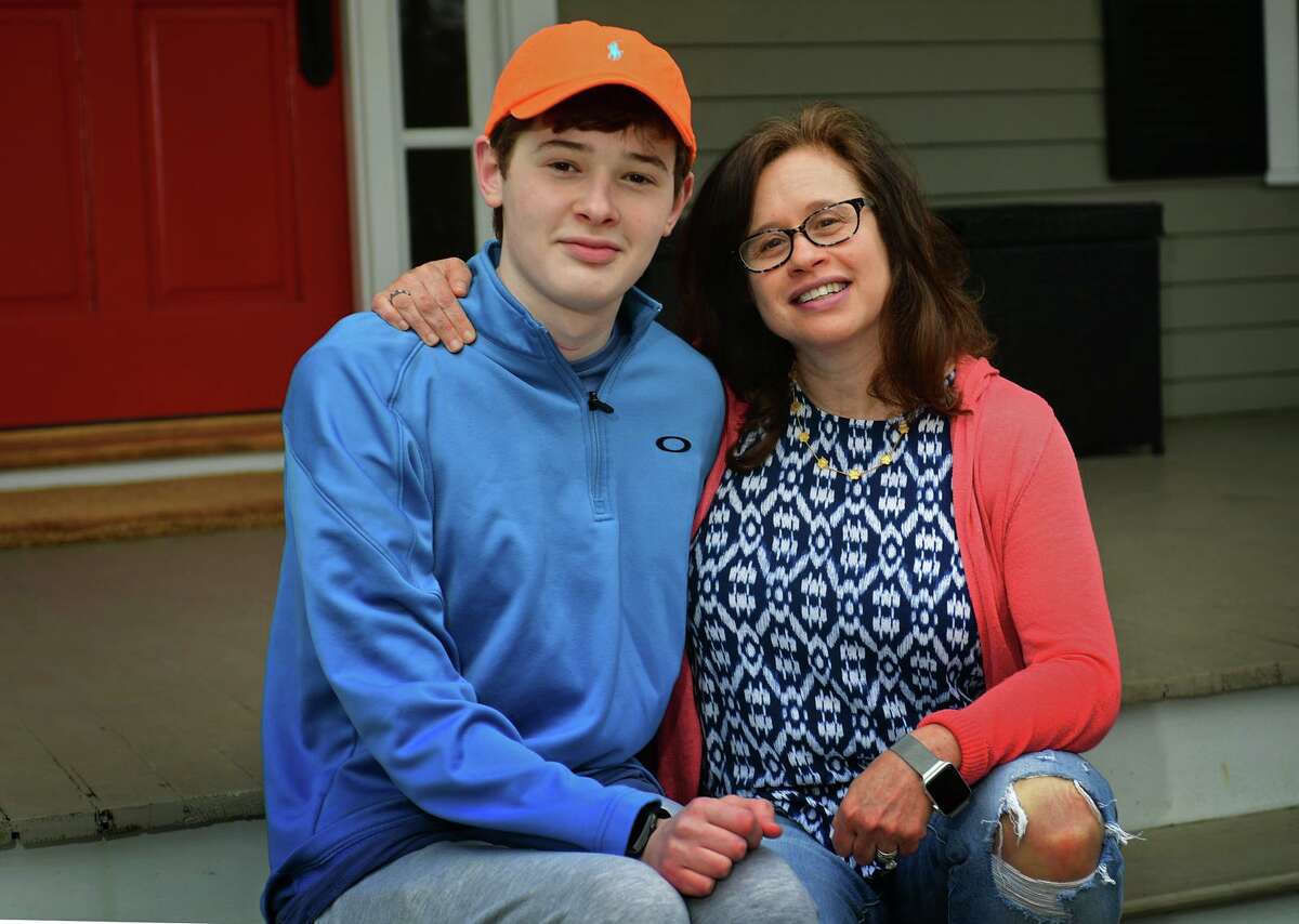 16-year-old, Luke Schwartz, and his mom, Deborah List at their home Thursday, April 1, 2021, in Wilton, Conn. Schwartz has a rare type of thyroid cancer and a host of other health issues and had hoped that, due to his health issues, he'd get the COVID vaccine early. But, when Lamont went by an age classification, His mother took matters into her own hands and got Luke vaccinated in Vermont, where the family also owns a home.