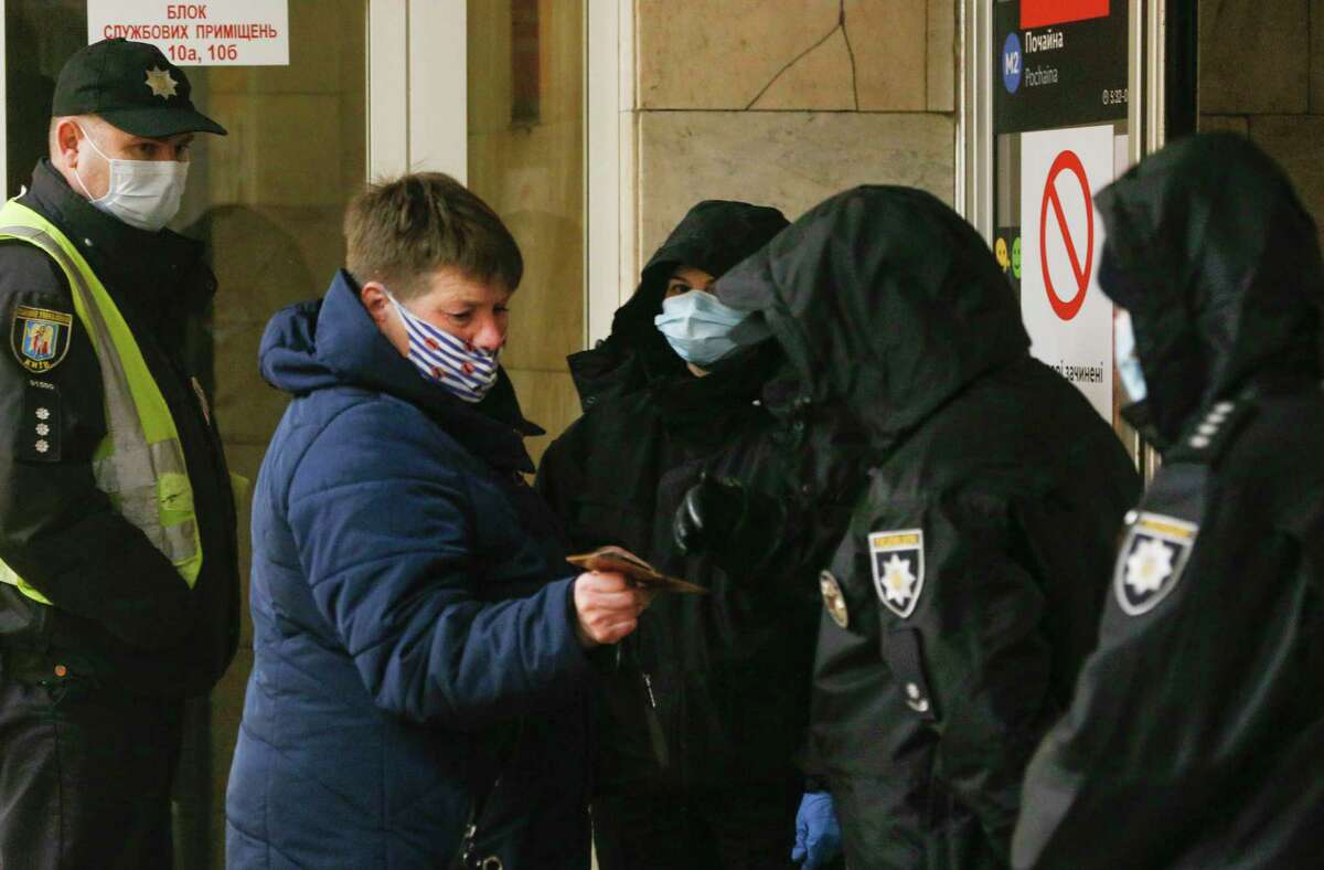 Policemen checks passenger passes at a subway station entrance in Kyiv, Ukraine, Monday, April 5, 2021. The city authorities have tightened an anti-coronavirus lockdown on Monday with more cases registered and hospitals overcrowded.