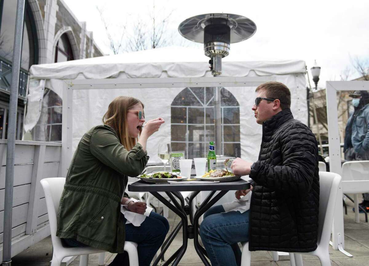 Stamford's Emily Levasseur and Craig Saphire enjoy a meal outside as part of the StrEATeries outdoor dining initiative in Stamford, Conn. Sunday, April 4, 2021. Stamford Downtown and the City of Stamford partnered to bring back the initiative that started last year in response to the ongoing coronavirus pandemic. StrEATeries adds more than 1,000 outdoor dining seats to accommodate visitors to downtown Stamford for dining and shopping.