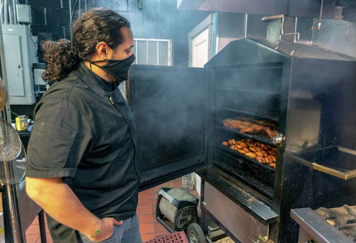 Emilio Soliz of Skywalk Sports Bar BBQ and Grill opens the smoker inside the restaurant and bar. He has been a pitmaster in the area for more than 15 years.