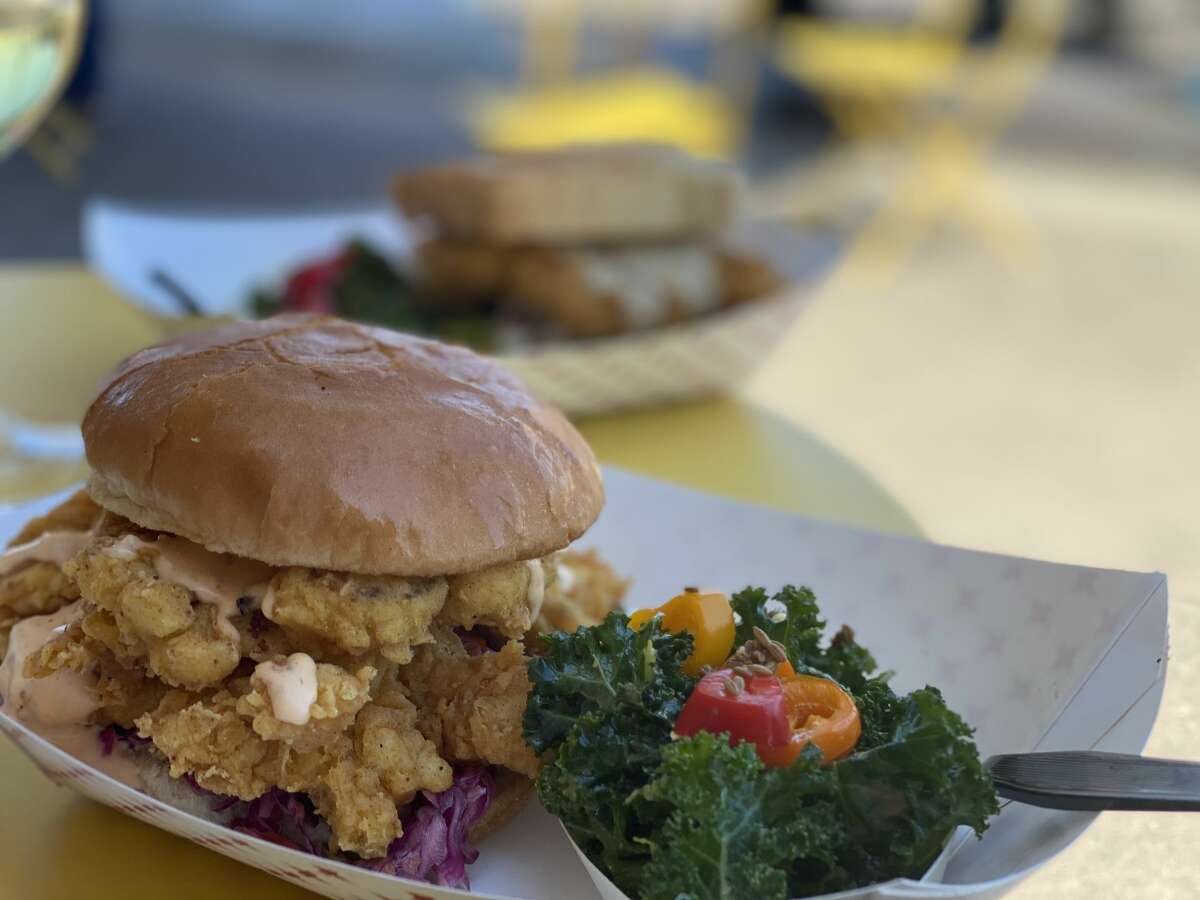 THE CON Want to enjoy a meal with a little kick? Then try The Con, a spicy "chickin" sandwich topped with a creamy sweet pepper slaw and serrano aioli.