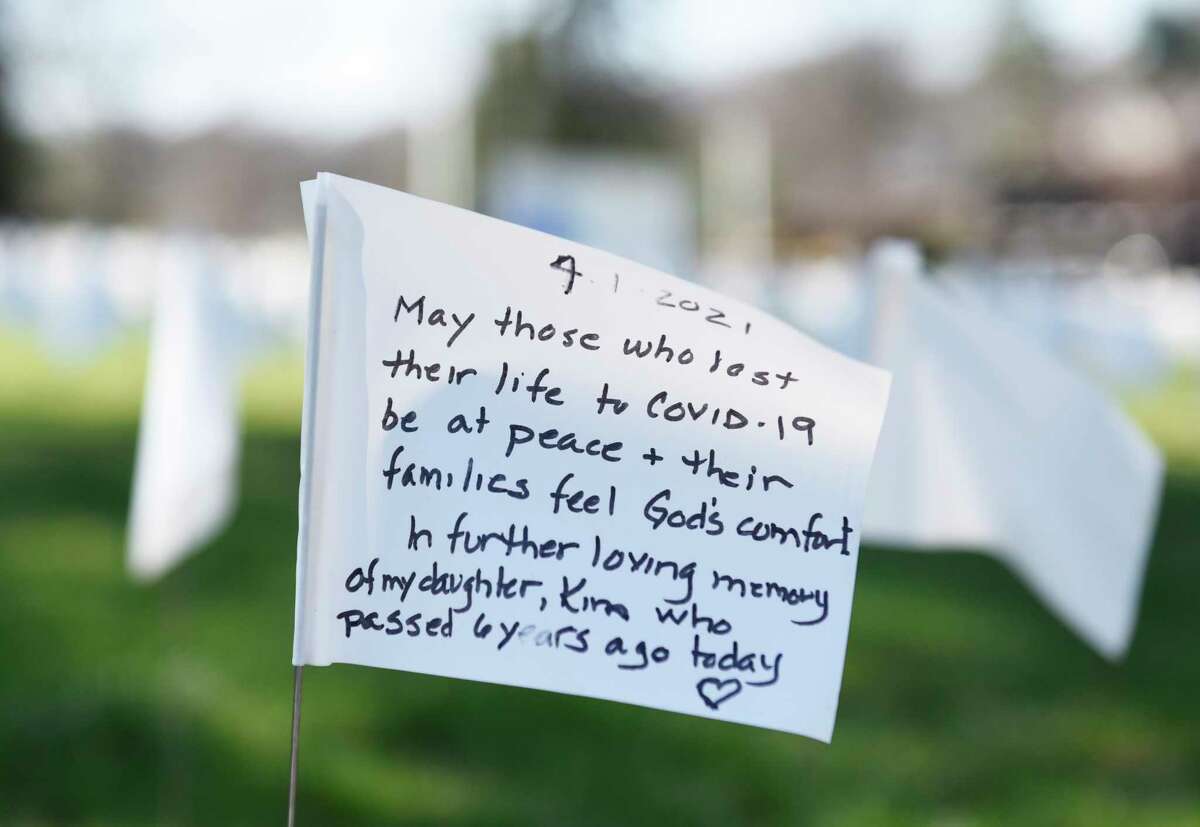 A message is written on one of the flags outside First Congregational Church of Greenwich in OldGreenwich, Conn. Monday, April 5, 2021. The flags were originally placed to mark each Connecticut life lost to COVID-19, but were eventually taken down. They were brought back for Holy Week as a way to bring closure after a year of enduring the coronavirus. The public was invited to take part in placing the flags and writing messages throughout the week.