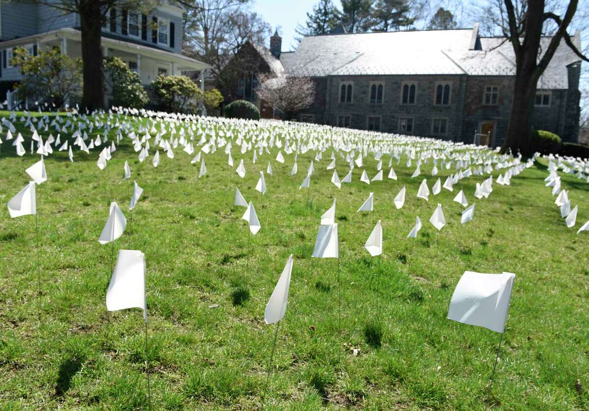 Thousands of white flags wave in the wind outside First Congregational Church of Greenwich in OldGreenwich, Conn. Monday, April 5, 2021. The flags were originally placed to mark each Connecticut life lost to COVID-19, but were eventually taken down. They were brought back for Holy Week as a way to bring closure after a year of enduring the coronavirus. The public was invited to take part in placing the flags and writing messages throughout the week.
