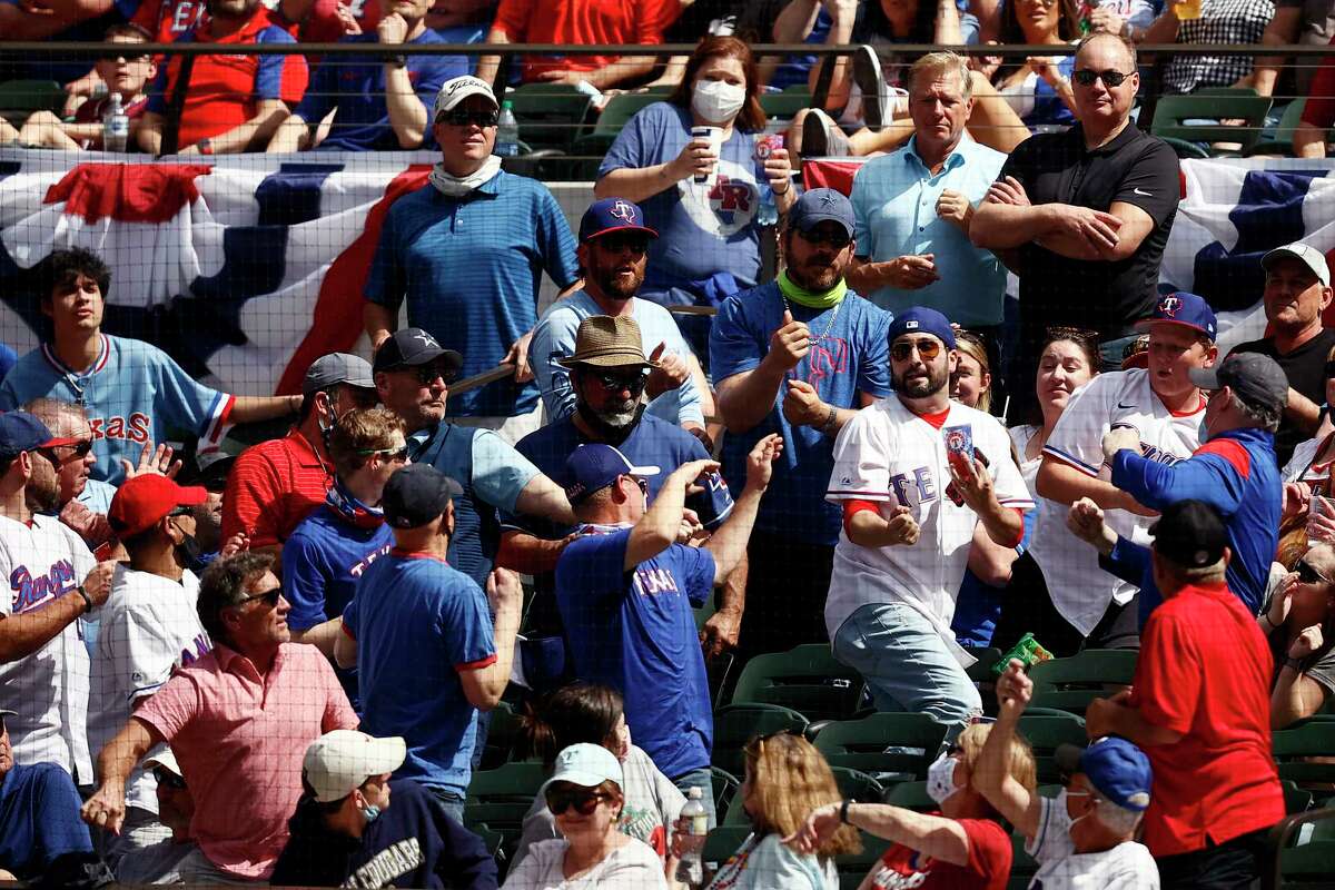 ARLINGTON, TEXAS - APRIL 05: Fans scramble for a foul ball in the second inning as the Texas Rangers take on the Toronto Blue Jays on Opening Day at Globe Life Field on April 05, 2021 in Arlington, Texas.