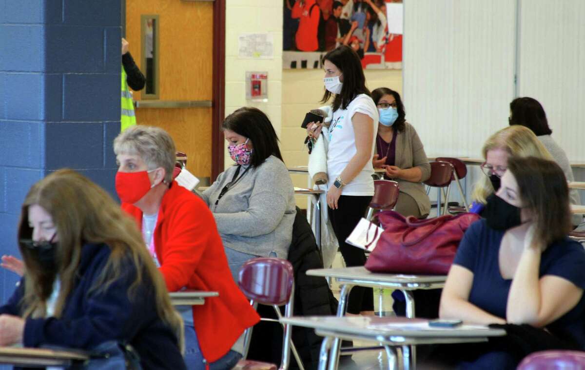 Teachers and staff from all over Monroe's school system wait the mandatory 15 minutes to monitor for reactions after receiving the COVID-19 vaccine during a closed vaccine clinic for Monroe school staff at Masuk High School in Monroe, Conn., on Wednesday Mar. 3, 2021.