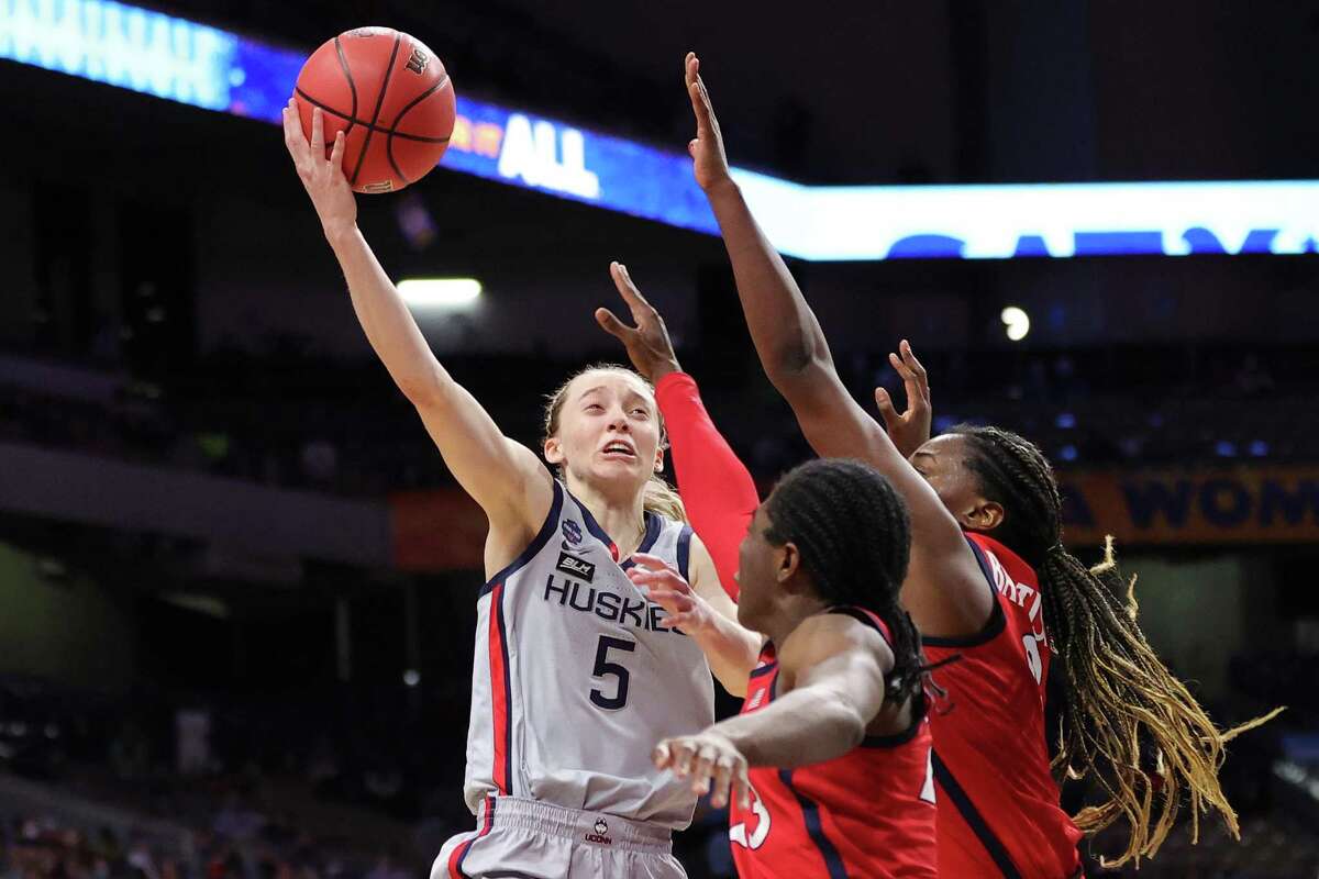 SAN ANTONIO, TEXAS - APRIL 02: Paige Bueckers #5 of the UConn Huskies shoots over Trinity Baptiste #0 of the Arizona Wildcats and Bendu Yeaney #23 in the Final Four semifinal game of the 2021 NCAA Women's Basketball Tournament at the Alamodome on April 02, 2021 in San Antonio, Texas. (Photo by Carmen Mandato/Getty Images)