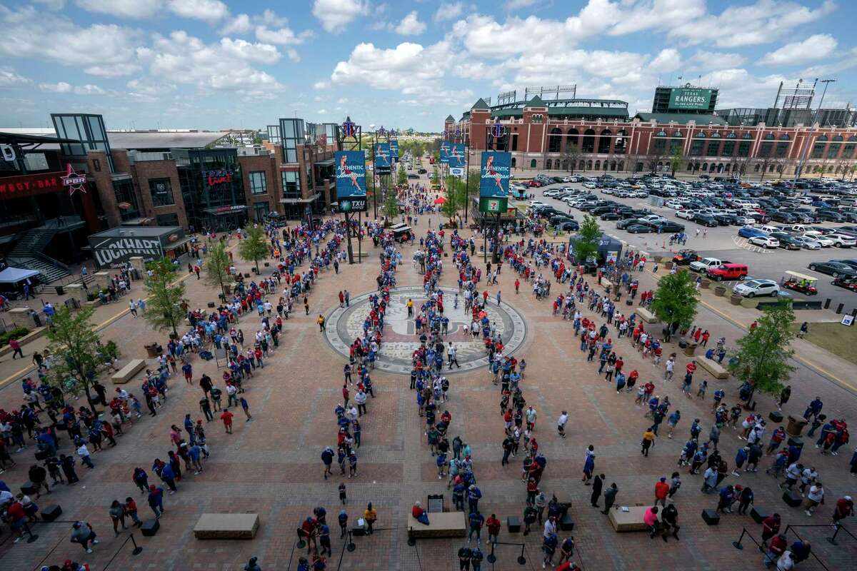 Fans line up to enter Globe Life Field before the Texas Rangers home opener baseball game against the Toronto Blue Jays on Monday, April 5, 2021, in Arlington, Texas. The Texas Rangers are set to have the closest thing to a full stadium in pro sports since the coronavirus shutdown more than a year ago. (AP Photo/Jeffrey McWhorter)