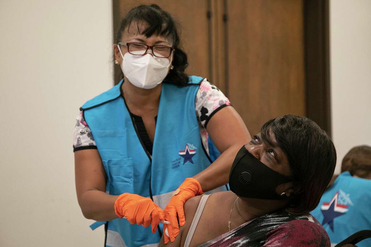 Nurse and volunteer Mary Young gives Geneva Pope her second dose of the coronavirus vaccine at Bethel AME Church in San Antonio on Monday.