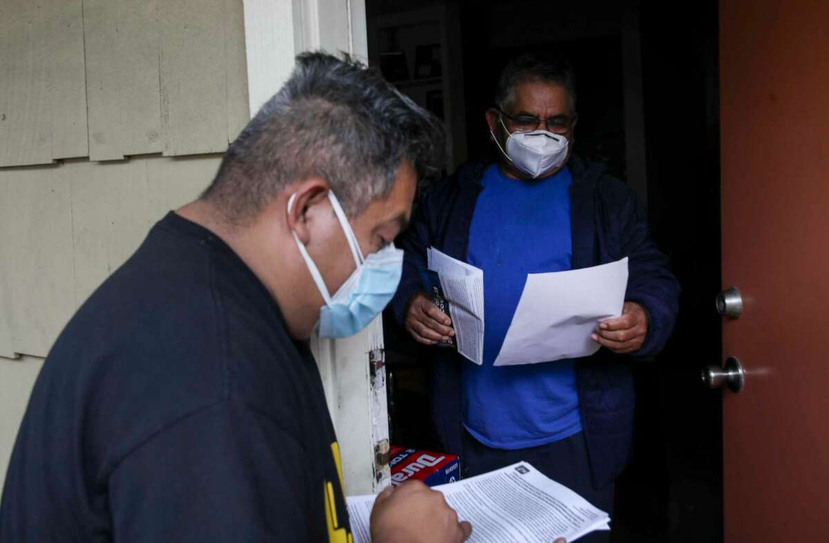 Adan Aurioles, right, talks with Alain Cisneros, an activist with FIEL Houston, about his rights as a tenant related to eviction proceedings Thursday, Feb. 4, 2021, at the Redford Apartments in Houston.