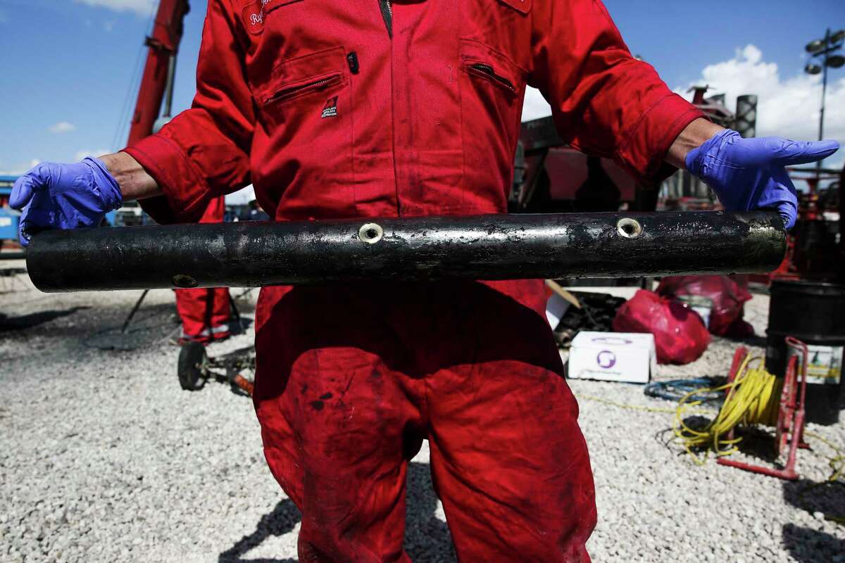 A worker holds a perforation charge pipe at a Chevron drilling site Wednesday, July 19, 2017 in Midland. Chevron contractors will inject sand and water through the pipe’s holes during hydraulic fracturing operations. ( Michael Ciaglo / Houston Chronicle )
