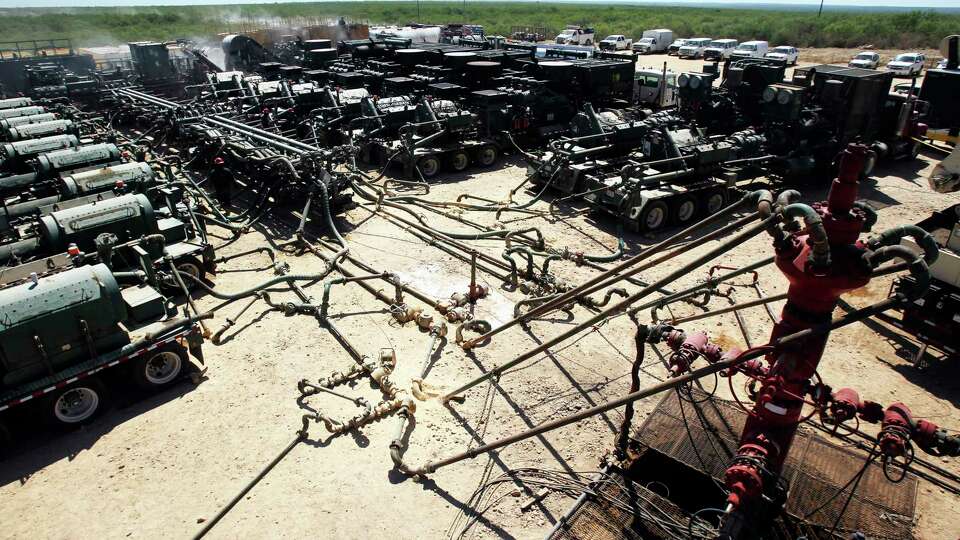 A well head, far right, is connected to pipes and hoses leading to a a partially visible fracking operation, at left and background. The operation includes manifolds and frac pumps at this Chesapeake Energy hydraulic fracturing operation near Carrizo Springs, Texas Thursday May 5, 2011. Hydraulic fracturing is a method of removing oil and gas from rock formations such as the Eagle Ford shale formation in south central Texas. John Davenport/ San Antonio Express-News