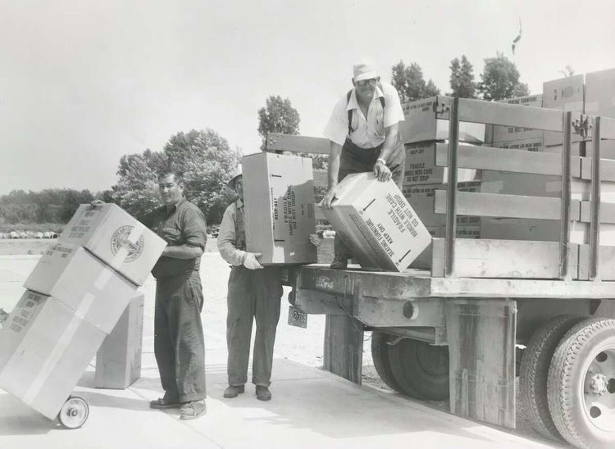 School maintenance crews under the direction of "Charlie" McCrary, on the school-owned truck, hands out equipment  for the new East Nelson school in preparation of the fall term. July 1955