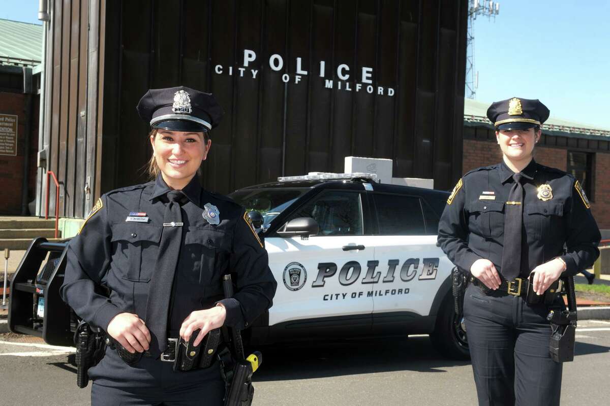 Milford Police Officers Nikki McMahon, left, and Kathleen Bruno pose in front of police headquarters, in Milford, Conn. April 5, 2021.