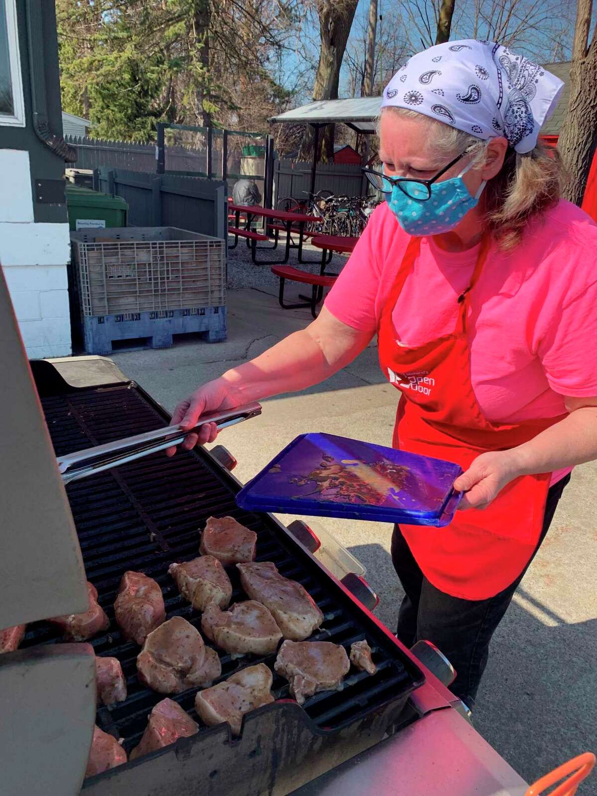 Volunteer Donna List is pictured grilling pork loin outside for the Open Door Easter dinner. (Photo Provided)
