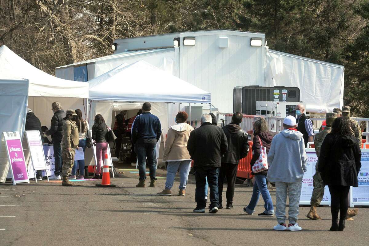 People wait in line for their scheduled COVID-19 vaccination appointments at FEMA’s new COVID-19 mobile vaccination unit, which is set up and running this week in parking lot of Connecticut’s Beardsley Zoo, in Bridgeport, Conn. March 29, 2021.