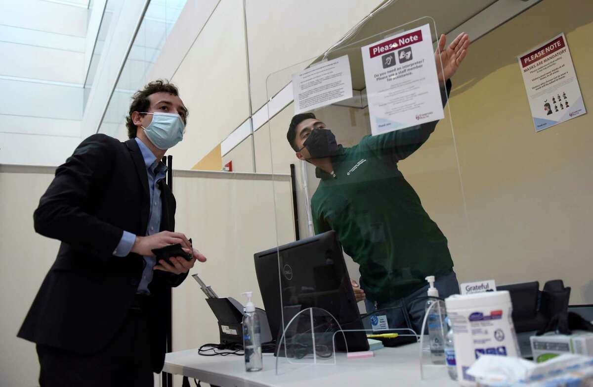 State Sen. Will Haskell, D-New Canaan, left, checks in before receiving his first dose of the COVID-19 vaccine at the Stamford Health Vaccination Super Site in Stamford, Conn. Tuesday, April 6, 2021. Beginning April 1st , all individuals 16 and older who live, work, or attend school in Connecticut became eligible to receive the COVID-19 vaccine.