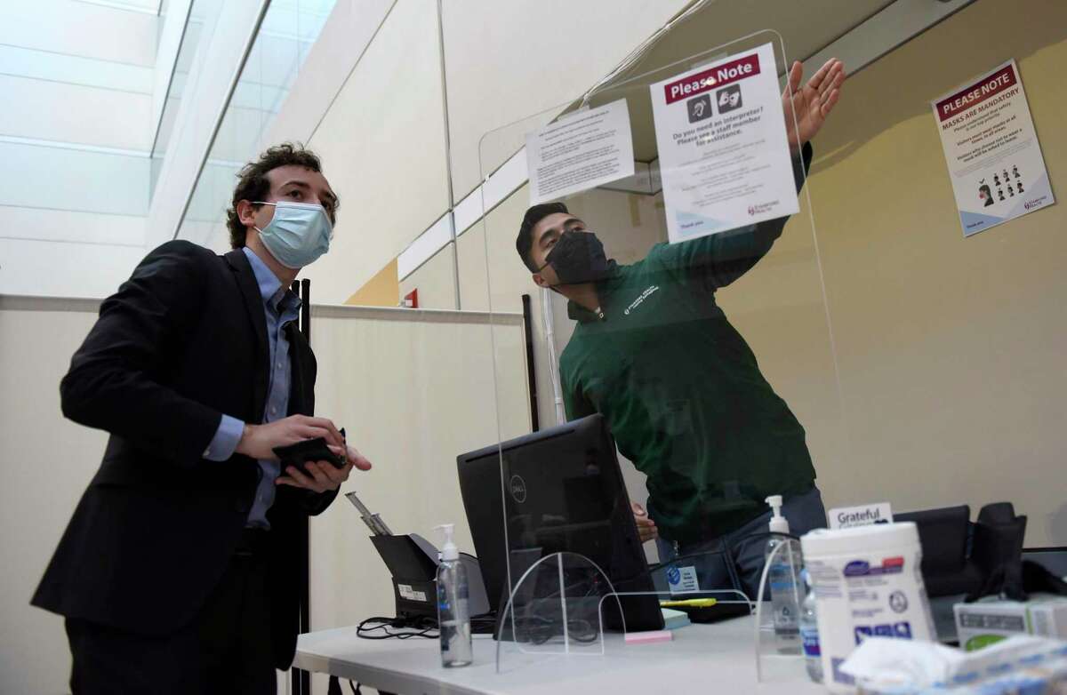 State Sen. Will Haskell, D-New Canaan, left, checks in before receiving his first dose of the COVID-19 vaccine at the Stamford Health Vaccination Super Site in Stamford, Conn. Tuesday, April 6, 2021. Beginning April 1st , all individuals 16 and older who live, work, or attend school in Connecticut became eligible to receive the COVID-19 vaccine.