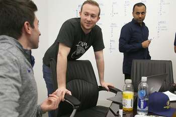 General manager for Santa Cruz Warriors Kent Lacob (left), VP of GSW sports ventures Kirk Lacob (middle) and director of basketball analytics Pabail Sidhu (right) from the Warriors' Gaming Squad gather at the Warriors offices in downtown Oakland to watch the proceedings on a screen and make decisions on top prospects on Wednesday, April 4, 2018, in Oakland, Calif.