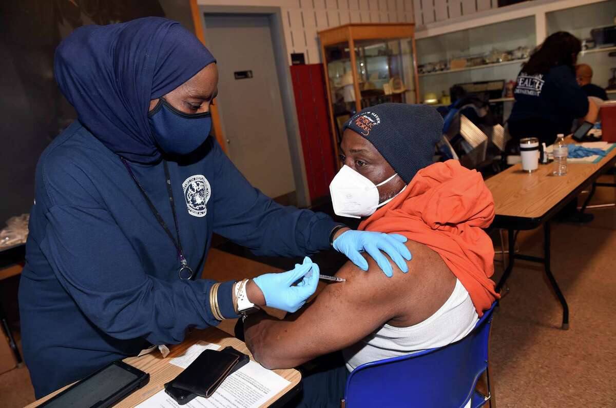 New Haven Health Department RN Maxine Singleton (left) gives a COVID-19 vaccination to William Kemp of the New Haven Public Works Department at the New Haven Regional Fire Training Academy in New Haven on April 7, 2021. City of New Haven employees were vaccinated at this location from 9:00 a.m. to 3:00 p.m.
