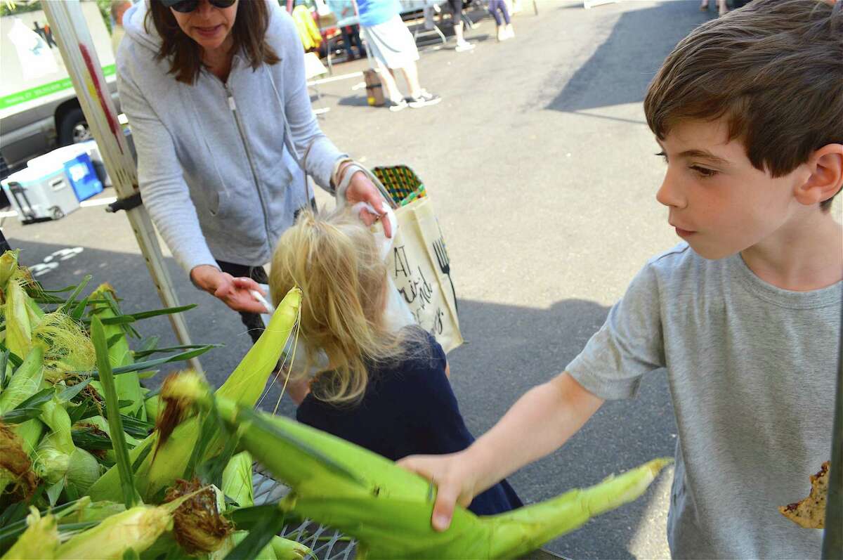 Adam Tomsky of New Canaan helps pick out corn at the New Canaan Farmers Market in August of 2017. Adam Tomsky, 5, of New Canaan, helps pick out corn at the New Canaan Farmers Market, Saturday, Aug. 12, 2017, in New Canaan, Conn.